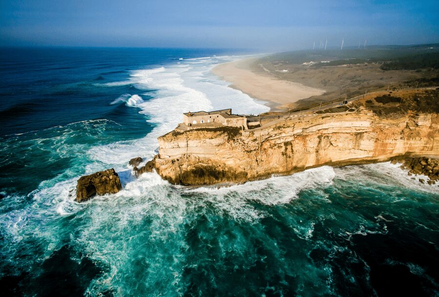 From Lisbon: Tour to Óbidos and Nazaré - Medieval Village, Ginja, and Giant Waves - Óbidos Castle walls and ginjinha in a chocolate cup