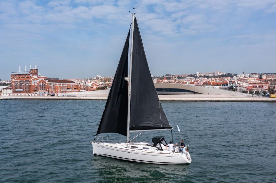 Lisbon: Private Sailboat Tour on the Tagus at Sunset - Under the bridge with Cristo Rei on the south shore