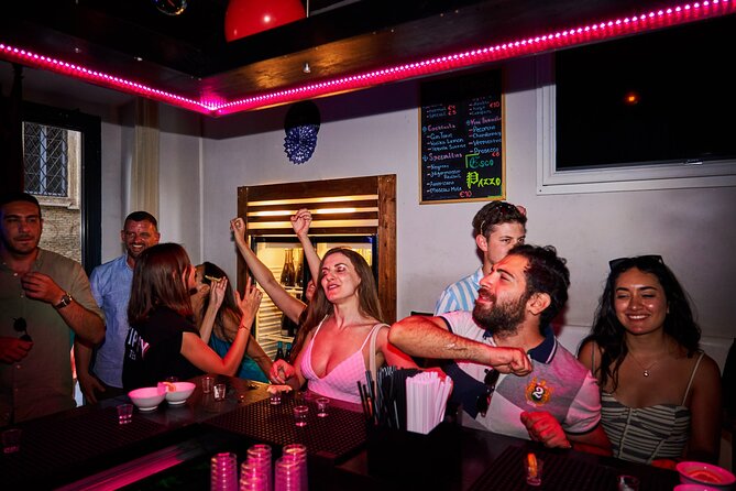 Lisbon Pub Crawl Walking Tour with Drinks Included - Bairro Alto at night: the bar streets with red-light history energy